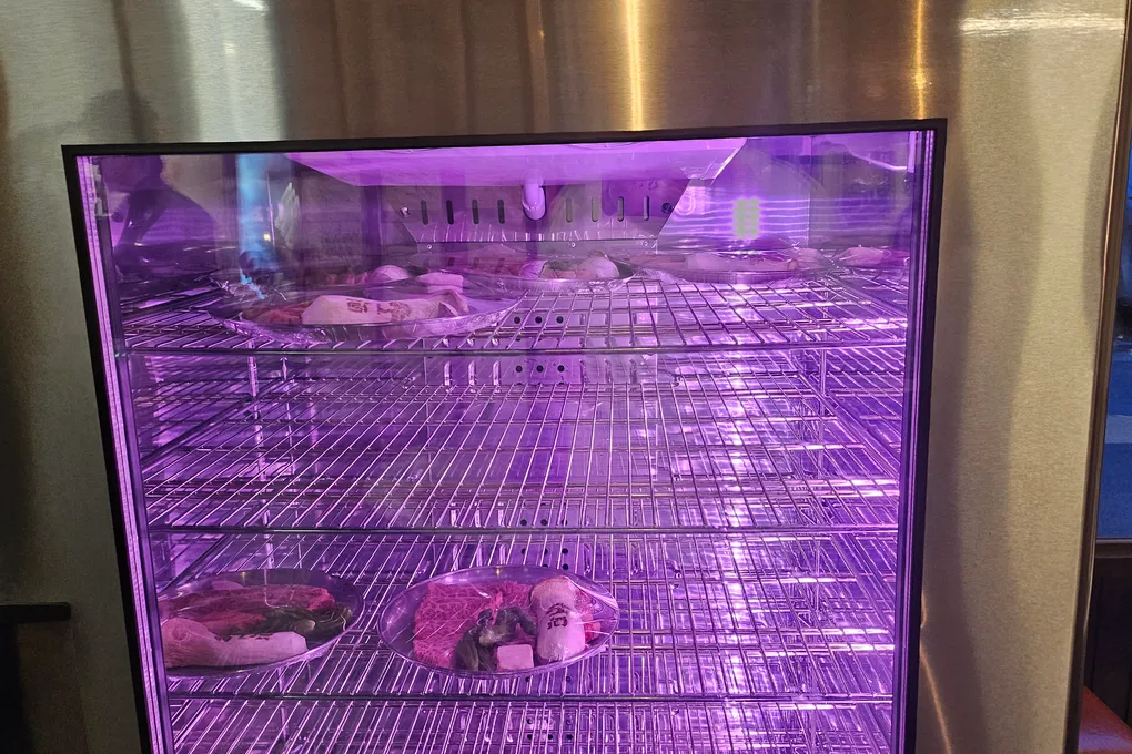 A dry-aging fridge at Baeksong with purple light, used to age hanwoo beef
