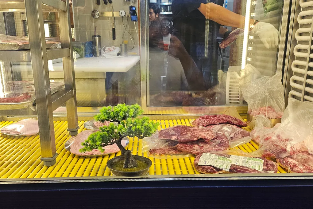 A refrigerated display case at Baeksong showing fresh cuts of hanwoo beef
