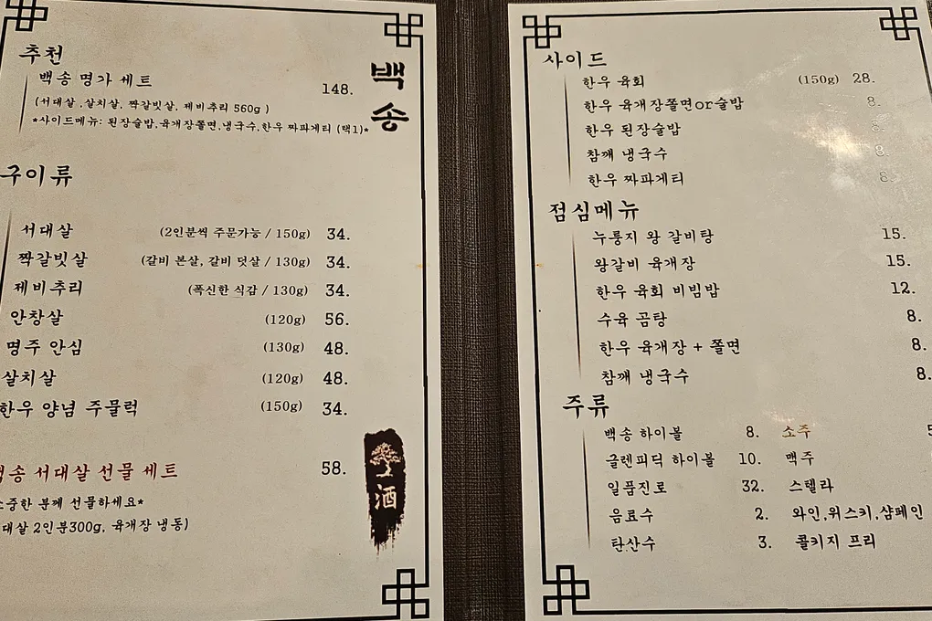 Baeksong's paper menu listing hanwoo cuts, sides, lunch sets, and drinks