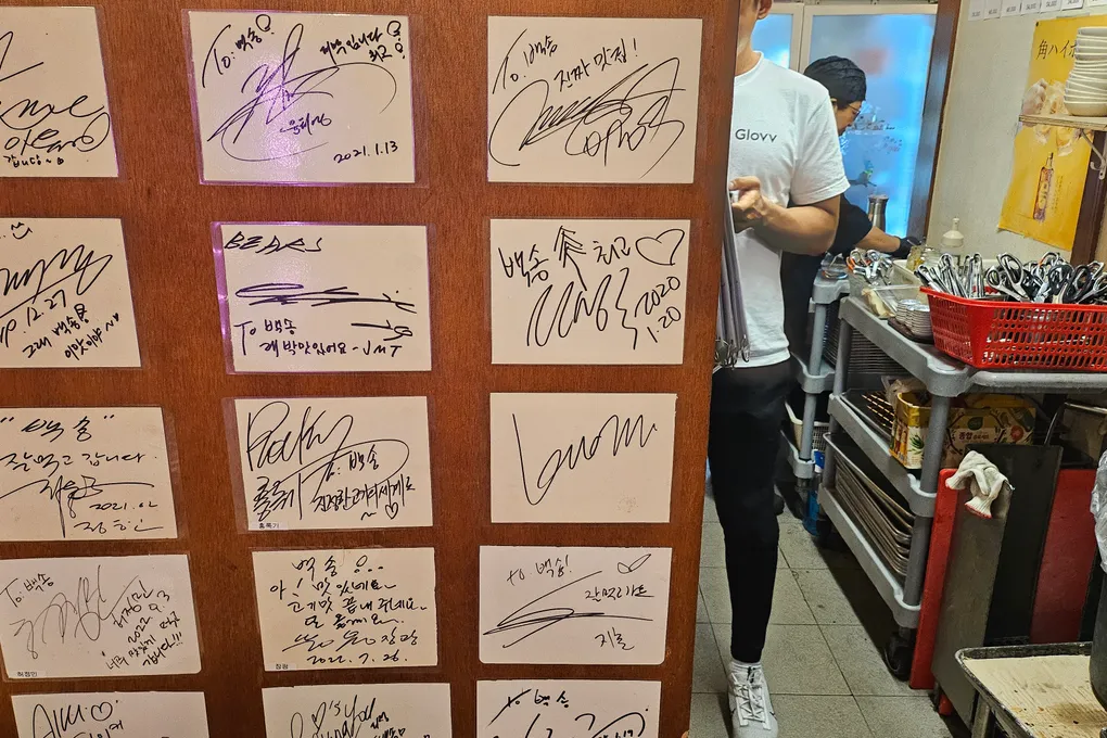 A wall covered with signed cards from Korean celebrities who have visited Baeksong