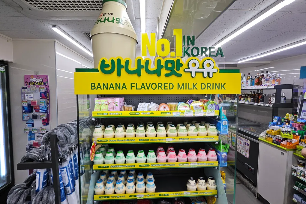 Shelves of flavored milk drinks in various colors at a Korean convenience store
