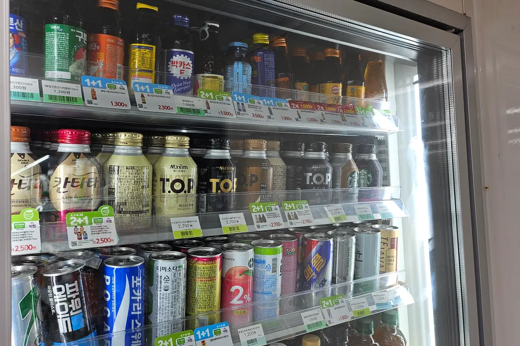 A drinks fridge packed with canned and bottled beverages at a Korean convenience store