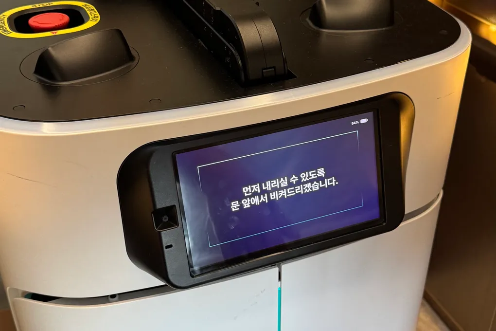 An autonomous room-service delivery robot in front of an elevator at Banyan Tree Seoul
