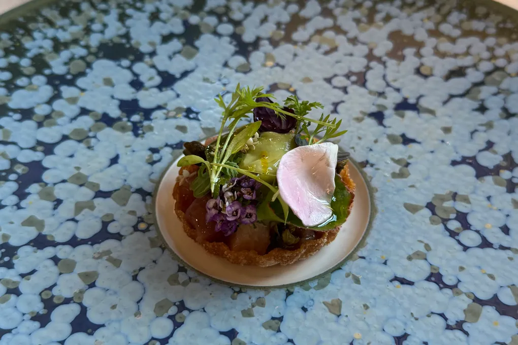 A delicate one-bite tart amuse-bouche on a speckled green plate at Festa by Choonghu