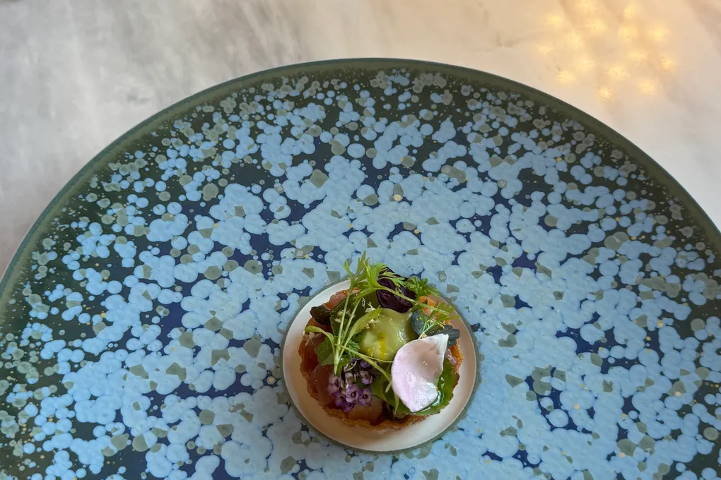 Amuse-bouche tarts plated on large speckled ceramic plates at Festa by Choonghu