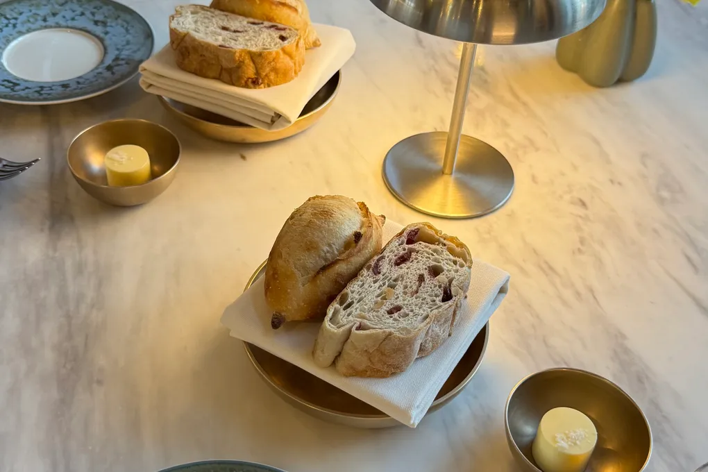 House-baked bread with whipped butter on a marble table at Festa by Choonghu