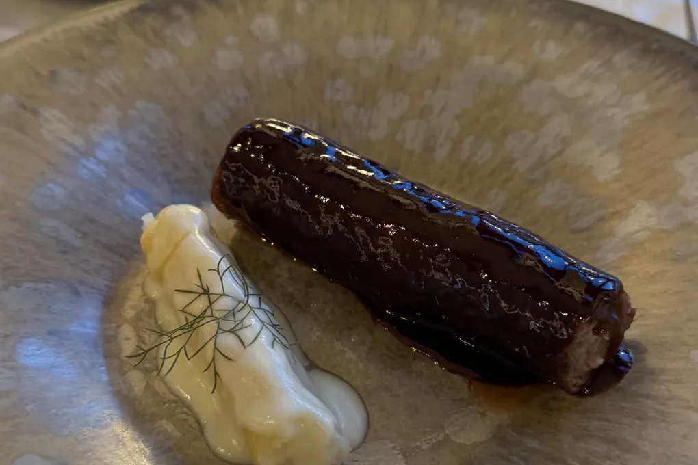 A glossy chocolate dessert with a quenelle of cream at Festa by Choonghu