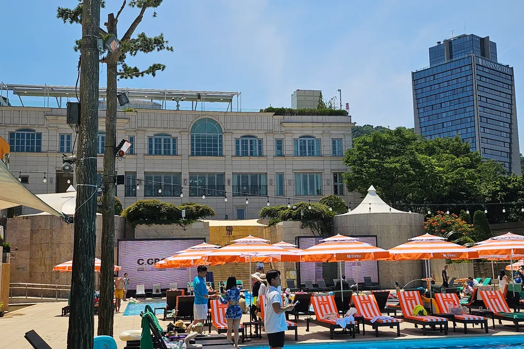 The Oasis outdoor pool at Banyan Tree Seoul with sun loungers and city buildings in the background