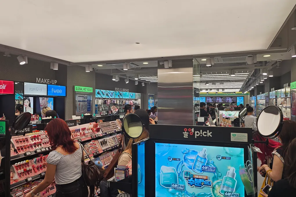 Inside an Olive Young store in Seoul with makeup displays, mirrors, and shoppers
