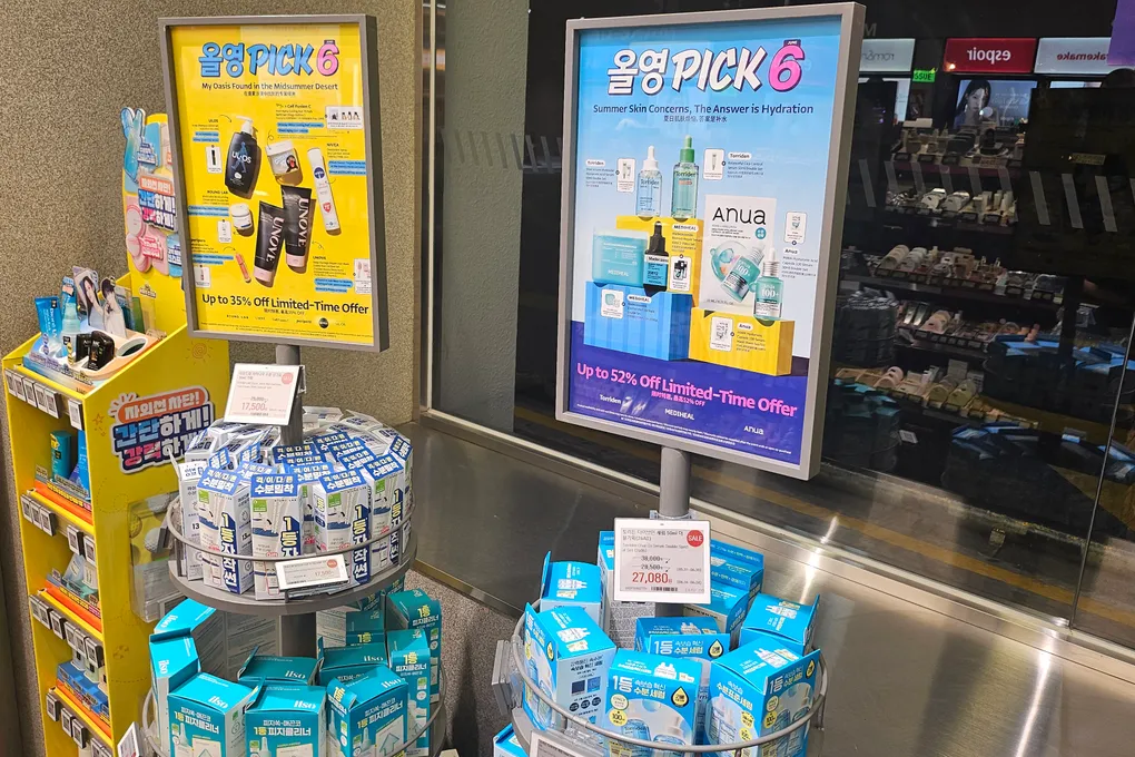 Olive Young PICK promotional display with summer sunscreens and Anua products, up to 52% off