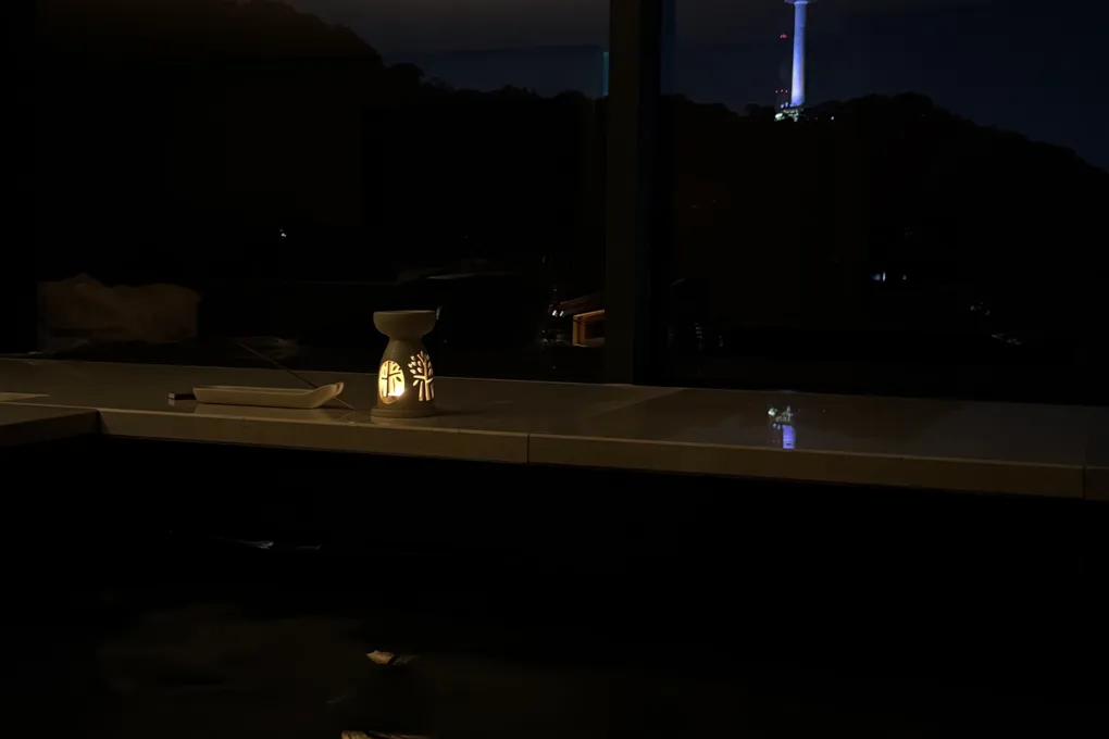 In-room pool at night at Banyan Tree Seoul with N Seoul Tower lit up through the window and two wine glasses