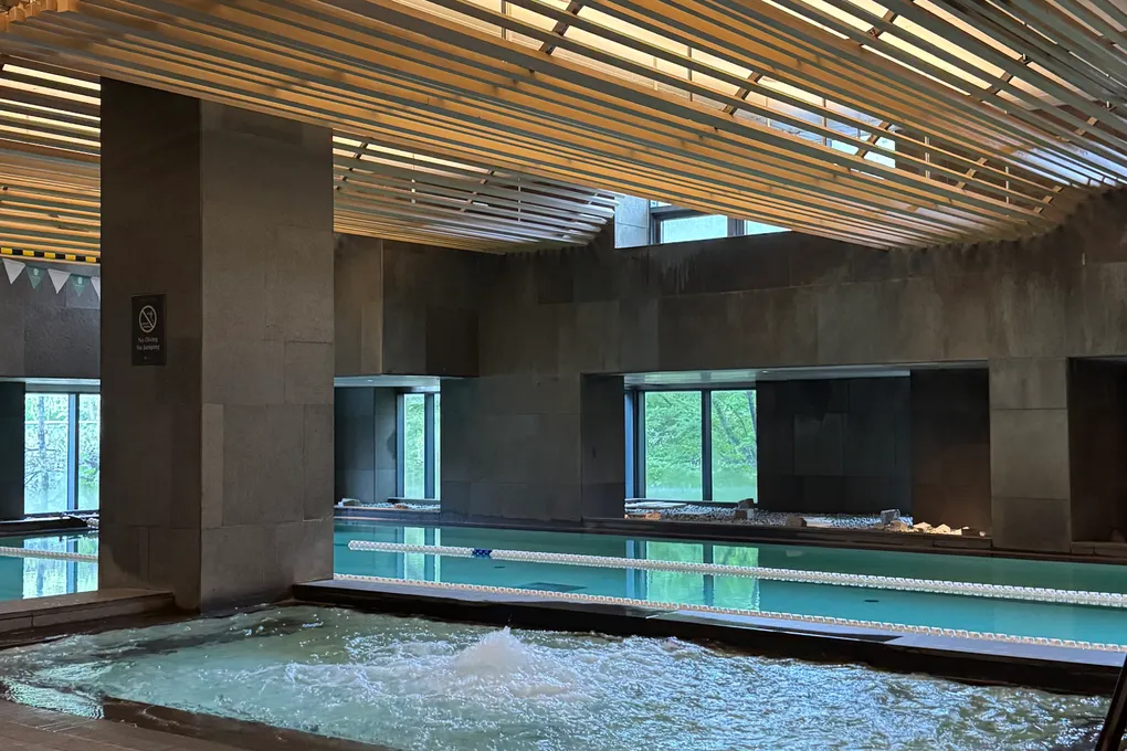 Jacuzzi and indoor pool with forest-view windows at Banyan Tree Seoul
