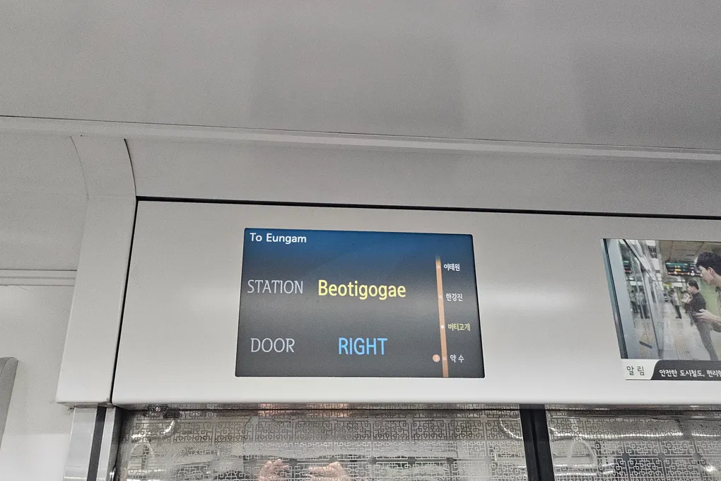 In-train display showing the next station Beotigogae and that doors open on the right, in English